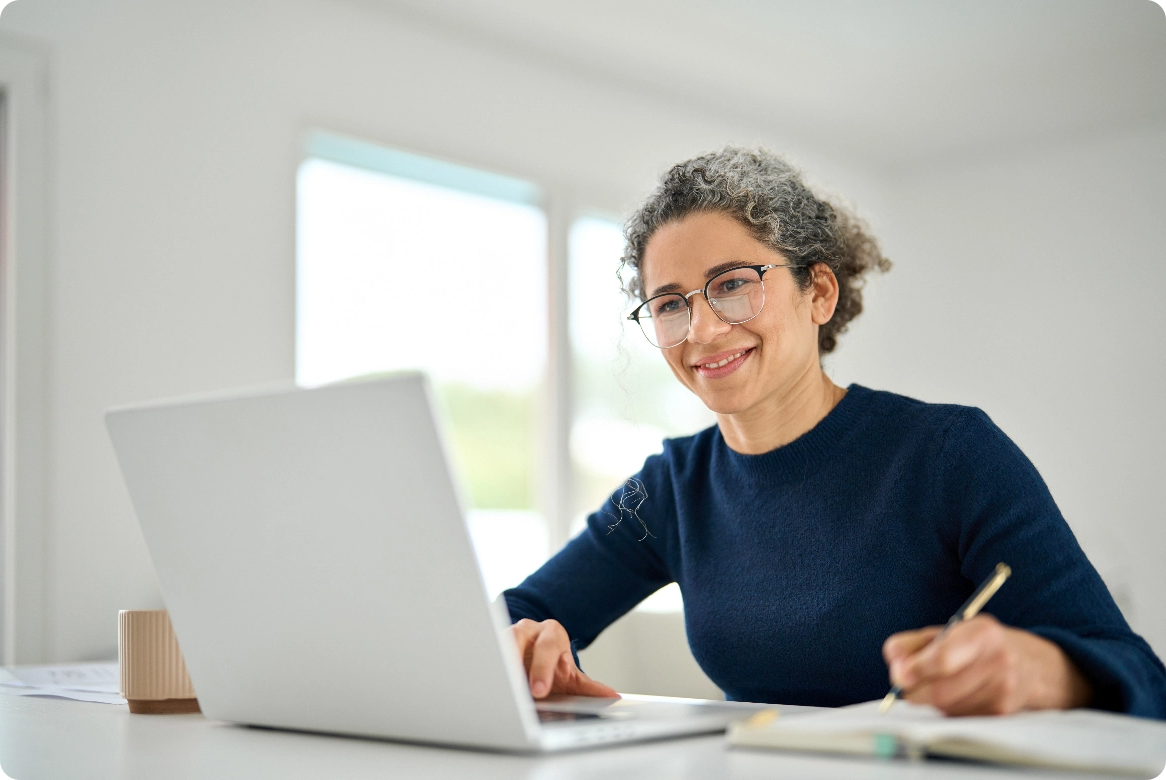 Woman using a laptop and notebook