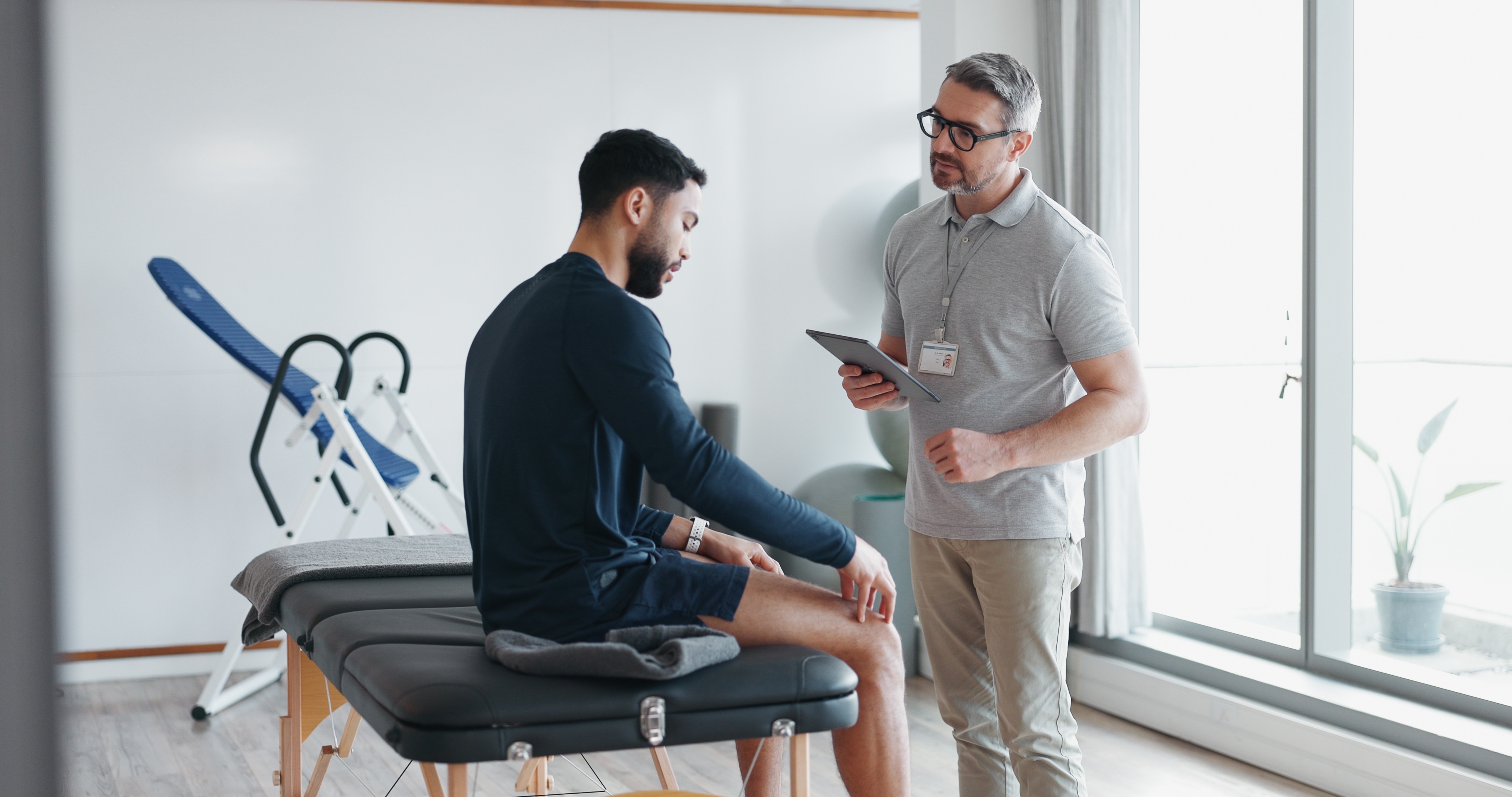 A chiropractor conducting an assessment of a patient with knee clicks and pain